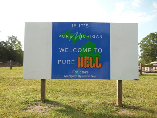Sign welcoming visitors to "Pure Hell," a humorous take on Michigan's tourism slogan, established in 1841.