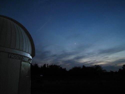 A darkening sky at dusk with wispy clouds, featuring the Frosty Drew Observatory in the foreground.