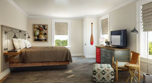 Cozy bedroom with a wooden bed, TV, red mini-fridge, and decorative paddle, featuring natural light and neutral tones.