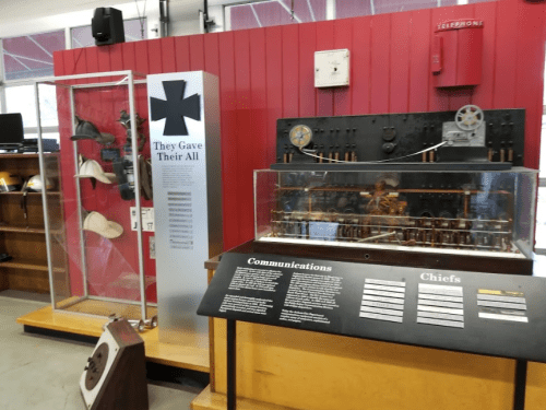 Display of historical communication equipment and artifacts, including a glass case and informational panels.