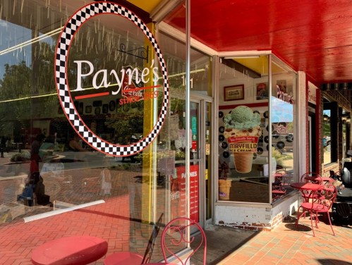 Exterior of Payne's ice cream shop with a checkered logo, red awning, and outdoor seating.