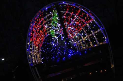 A colorful display of lights in a dark setting, featuring red, blue, and green patterns resembling festive decorations.