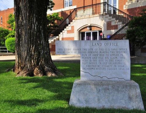 A stone marker detailing the historic U.S. Land Office site from the 1889 land run in Oklahoma.
