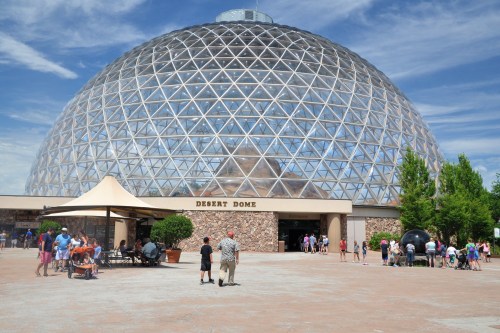 A large glass dome structure labeled "Desert Dome" with visitors outside on a sunny day.