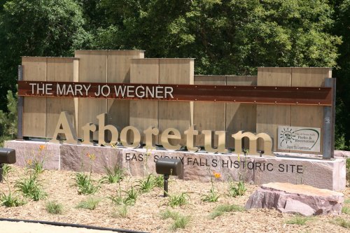Sign for the Mary Jo Wegner Arboretum at East Sioux Falls Historic Site, featuring wooden and stone elements.