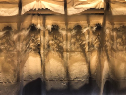 A textured fabric with floral patterns casting soft shadows against a light background.