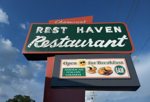 Sign for Rest Haven Restaurant, featuring breakfast hours and cuisine types: American, Italian, and Lebanese.