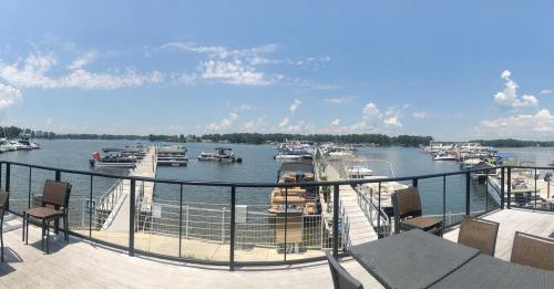 A panoramic view of a marina with boats docked, under a clear blue sky with scattered clouds.