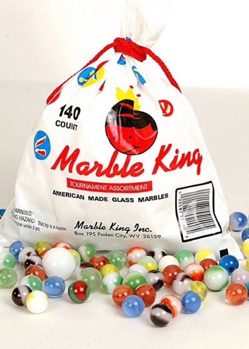 A bag of 140 colorful glass marbles scattered on a surface, labeled "Marble King Tournament Assortment."