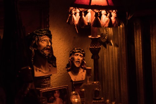 Two religious statues of Jesus with a crown of thorns, illuminated by warm light from a nearby lamp.