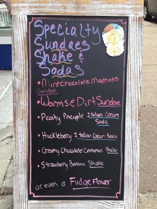 Chalkboard menu listing specialty sundaes, shakes, and sodas, including Mint Chocolate Madness and Worms & Dirt Sundae.