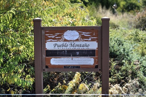 Sign for Pueblo Montaño Trailhead, featuring information about the area and its natural features.