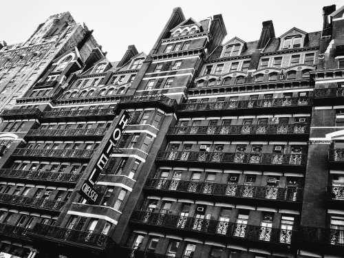 Historic Chelsea Hotel facade in black and white, featuring intricate architectural details and balconies.