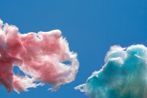 Fluffy pink and blue cotton candy against a clear blue sky.