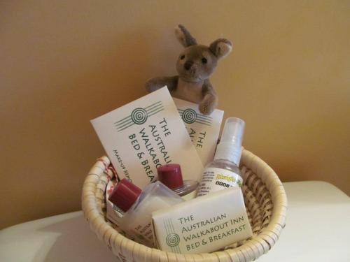 A woven basket containing toiletries, brochures for a bed and breakfast, and a small stuffed kangaroo toy.