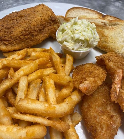A plate featuring fried fish, shrimp, French fries, coleslaw, and toasted bread.