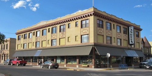 Historic Andrus Hotel building with a brick facade, large windows, and a classic sign, set against a blue sky.
