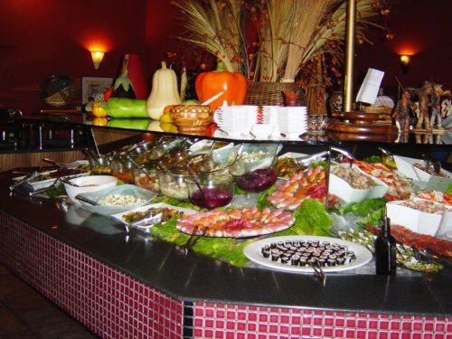 A vibrant buffet display featuring various dishes, including seafood, salads, and colorful vegetables.