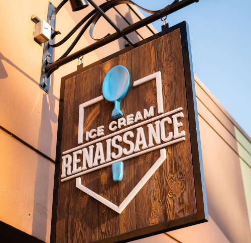 Sign for "Ice Cream Renaissance" featuring a blue spoon on a wooden background.