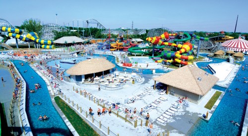 A vibrant water park with slides, pools, and people enjoying the sun on a clear day.