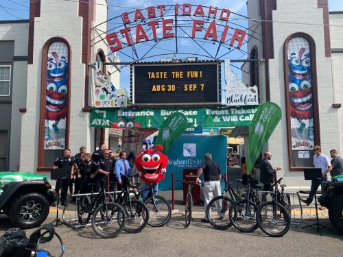 A colorful entrance to the East Idaho State Fair with a character mascot, bikes, and event banners.
