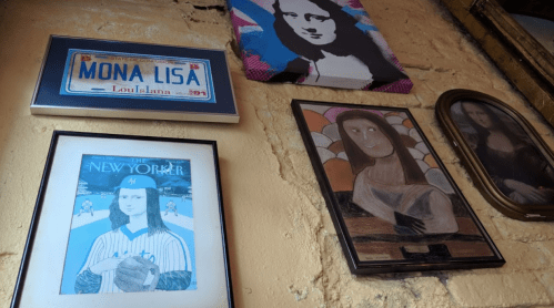 A wall display featuring various artistic interpretations of the Mona Lisa and a New Yorker magazine cover.