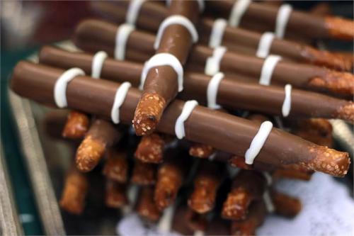 Chocolate-covered pretzel sticks with white drizzle arranged in a decorative pile.