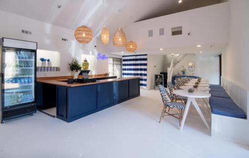 Bright, modern café interior with a wooden counter, striped decor, and seating area featuring blue and white accents.