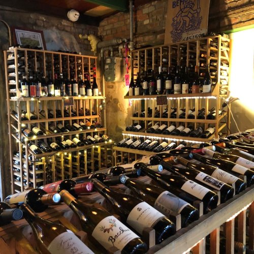 A cozy wine cellar with wooden racks filled with various bottles of wine, creating a warm and inviting atmosphere.