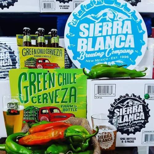 A display featuring Sierra Blanca Brewing Company products, including Green Chile Cerveza, bottles, and fresh green chiles.