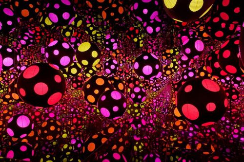 Colorful spheres with polka dots in vibrant pink, purple, and yellow, creating a mesmerizing, reflective pattern.