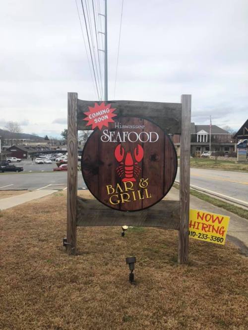 Sign for Hiawassee Seafood Bar & Grill, indicating "Coming Soon" and a hiring notice at the bottom.