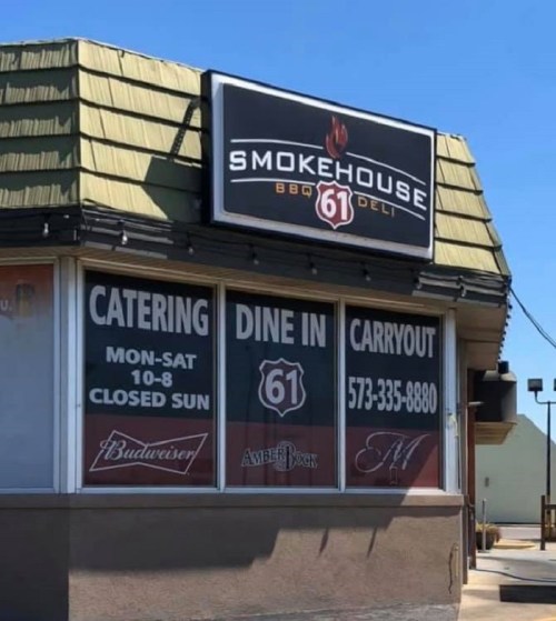 Sign for Smokehouse 61 BBQ Deli, featuring catering, dine-in, and carryout options, with business hours and contact info.