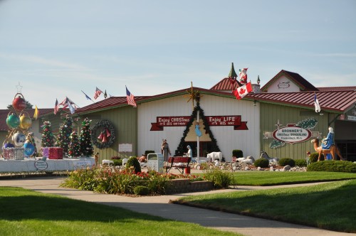 A festive outdoor scene featuring a Christmas store with decorations, flags, and holiday displays.