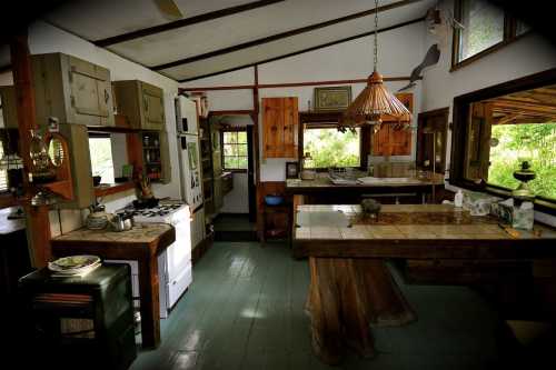 Cozy kitchen with wooden accents, a large table, and natural light streaming through windows.