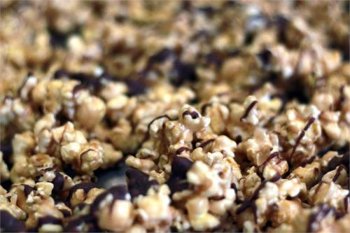 Close-up of caramel popcorn drizzled with chocolate, creating a sweet and crunchy snack.
