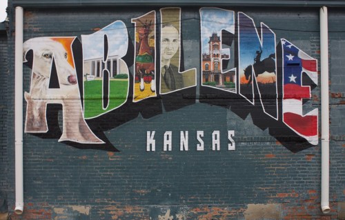 Colorful mural spelling "Abilene, Kansas" with images of a sheep, historical figures, and local symbols.