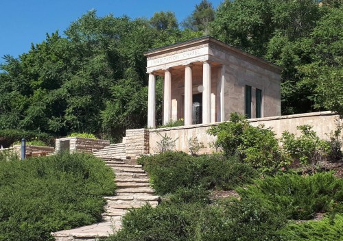 A stone chapel with columns, surrounded by greenery and steps leading up to it, labeled "Meditation Chapel."