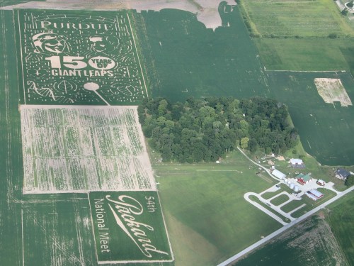 Aerial view of a cornfield featuring designs for Purdue's 15 Years of Giant Leaps and the 54th Packard National Meet.