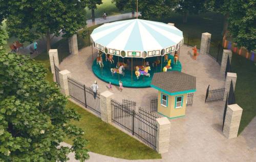 A colorful carousel surrounded by a fence, with children and adults enjoying the park on a sunny day.