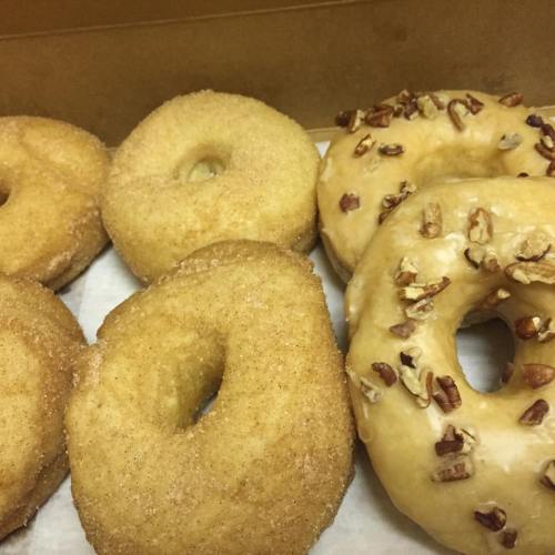 A box of assorted donuts: two cinnamon sugar and two glazed with pecans.
