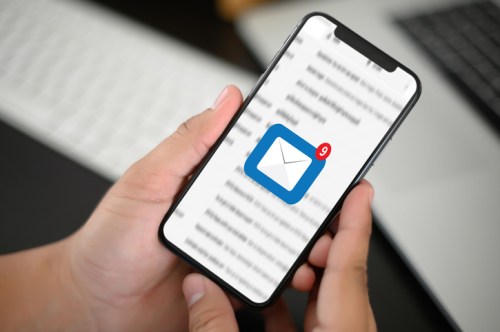 A person holding a smartphone displaying an email app with a notification of nine new messages.