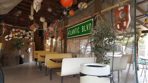 Interior of a rustic restaurant with nautical decor, including life buoys and a sign reading "Atlantic Blvd."