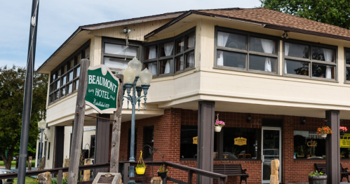 Exterior view of the Beaumont Hotel, featuring large windows and a sign, with a cozy, inviting atmosphere.