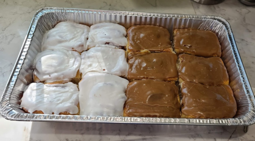 A tray of frosted pastries, half with white icing and half with brown icing, arranged in a grid pattern.