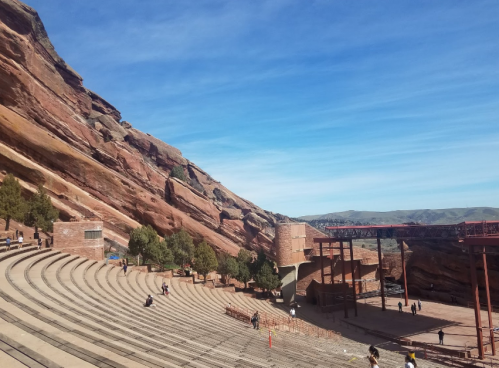 A view of Red Rocks Amphitheatre with natural rock formations and a clear blue sky in the background.