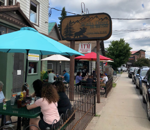 Outdoor seating at Walt's Diner, with colorful umbrellas and diners enjoying meals on a sunny day.