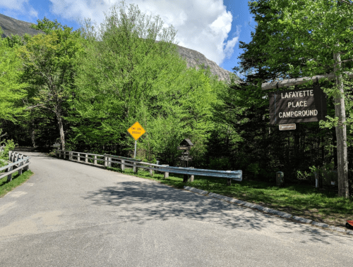Entrance to Lafayette Place Campground, surrounded by lush green trees and a clear blue sky.