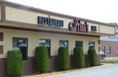 Exterior of Irina's Restaurant and Bar, featuring a sign and neatly trimmed bushes in front.