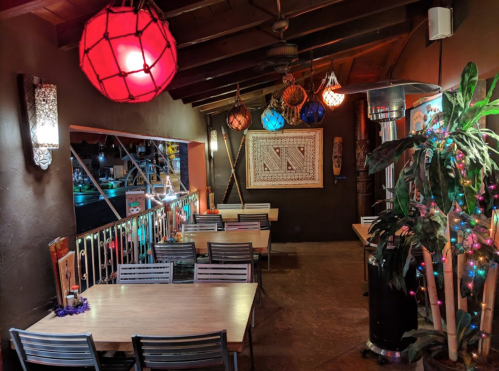 Cozy restaurant interior with colorful lanterns, wooden tables, and a warm ambiance.